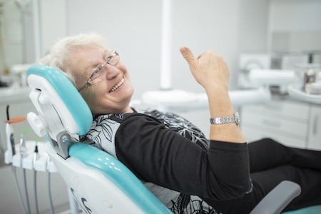 dentist speaking with patient in exam chair